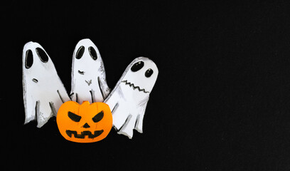 Ghosts playing at scaring, coming out from behind a horrifying pumpkin.