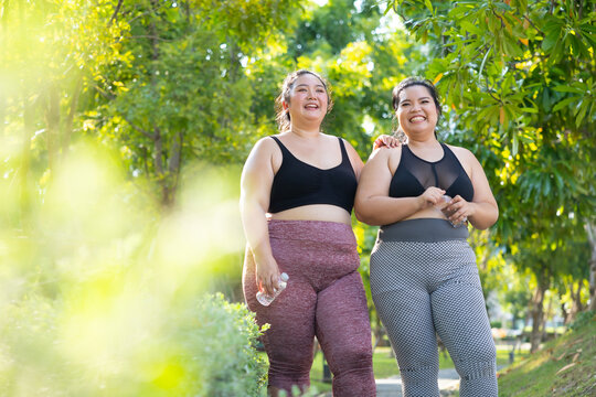 LGBTQ couple.Two smiling sporty young chubby overweight women in sportswear walking in park after workout. fitness sport club, body and health care. Outdoor Activity