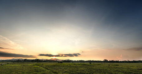 Sunset sky clouds over field  in the evening with golden sunset, horizon sky landscape in summer countryside backgrounds 