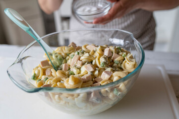 Traditional german pasta salad prepared by woman´s hands in the kitchen