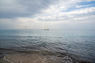 Some vessels moored in front the horizon nearby the shoreline at sunset. 