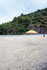 Stretch of sandy beach along the promontory at sundown. Marina di Camerota bay, Salerno, Italy.