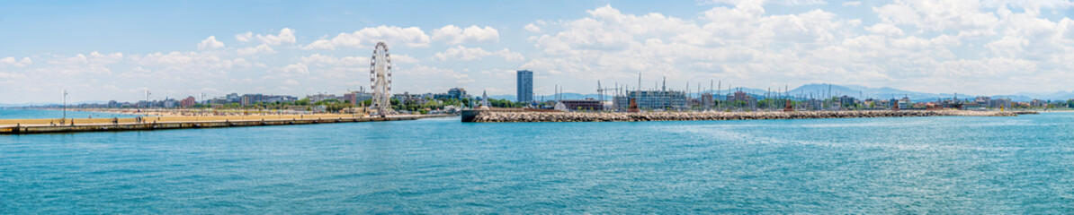 A panorama view from the harbour breakwater down the harbour estuary at Rimini, Italy in summertime