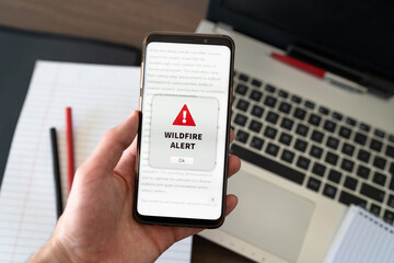 Wildfire notification appearing on the phone while in use. Hazard concept and climate change