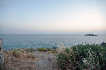 View of the horizon with an islet at twilight. Marina di Camerota, Salerno, Italy.