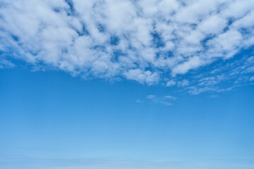 Beautiful, blue sky background with puffy white clouds on a sunny day.