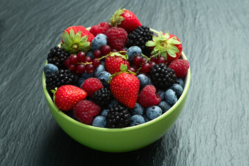 Mix of ripe colorful berries in bowl photography . Blueberry , strawberry , raspberry , blackberry and red currant . Top view