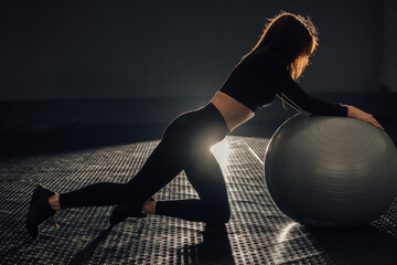 A dynamic workout with a stability ball in dramatic lighting creates an energetic atmosphere,...