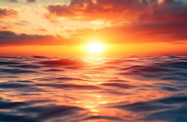 Obraz premium A breathtaking sunrise over the ocean, casting a golden glow on the water. The sun is just breaking through the clouds, creating a dramatic and peaceful scene.