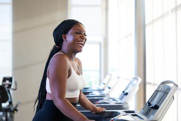 jogging on treadmill. beautiful young chubby overweight african american woman wearing sporty fitness clothes doing exercise indoors at gym fitness sport club, body and health care