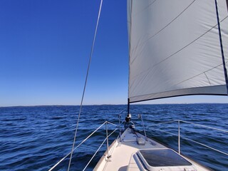 Fototapeta premium Luxury cruise on a sailing rigged yacht under a genoa and mainsail sailing in a light wind during the regatta. Yachting as a luxury sport and great vacation