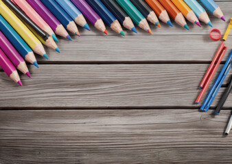 Colored pencils on a wooden table. Back to school concept. Stationery composition.