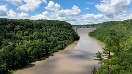 Fototapeta premium Mt Morris Dam in New York State on Genesse River at Letchworth State Park with blue sky and clouds in a beautiful countryside landscape with green trees in summer season
