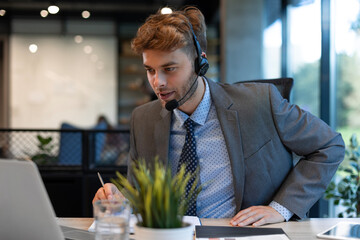 Smiling friendly handsome young male call centre operator.