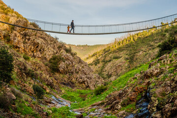 Father and son walking on hanging bridge in Algarve, Portugal