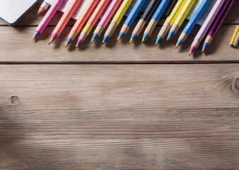 Colored pencils on a wooden table. Back to school concept. Stationery composition.