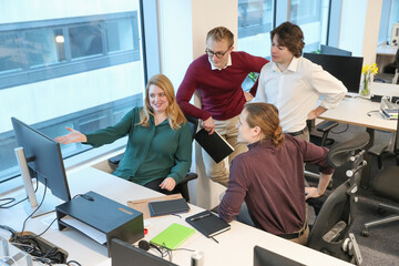 Obraz premium Employees looking at computer in office