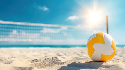 Obraz premium Yellow and white volleyball on sandy beach with net and bright sun, perfect summer day for beach sports with blue sky and ocean in the background.