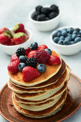 Stack of homemade american pancakes with berries . Top view