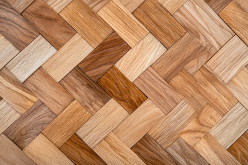 Close-up of a wooden parquet floor with a herringbone pattern, showcasing various shades and textures of natural wood.