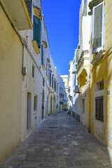 A narrow street in the historic center of Gallipoli, a tourist town in Puglia in Italy.
