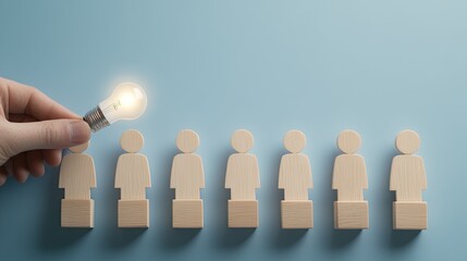 A businessman lifts an LED light bulb above wooden figures, illustrating the connection between human resources and innovative ideas in the business world