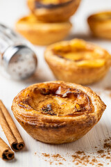 Close-up of Traditional Portuguese Custard Tart (Pastel de Nata) with Cinnamon Sticks