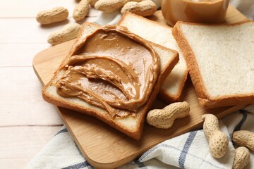 Naklejka premium Delicious sandwich with peanut butter and nuts on white wooden table, closeup