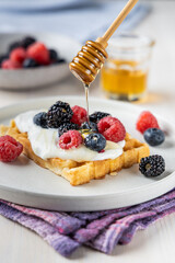 Fresh Waffle with Mixed Berries and Cream Topped with Honey