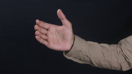 Close up male hand holding something like a bottle or can isolated on black background