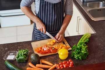 Hands, man and cutting with vegetables for health, nutrition or vegan diet for wellness. Male...