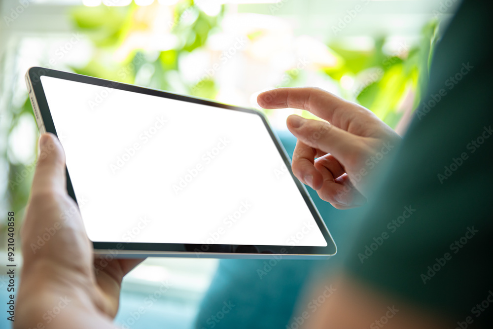 Poster person holding a tablet with a blank screen, in a bright, green environment. perfect image for prese