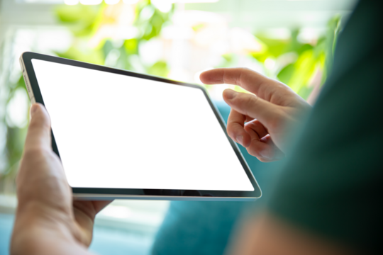 Person holding a tablet with a blank screen, in a bright, green environment. Perfect image for presenting tablet apps, user interfaces, or graphic designs.