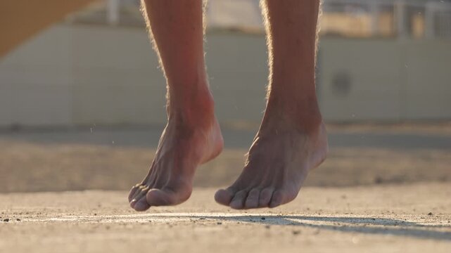 Outdoor sport training, man jumping with rope, joyful athlete is energetically jumping and skillfully skipping rope on the ground, street park sport place, barcelona, spain.