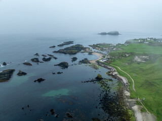 Ballintoy Harbour kleiner Ort mit Hafen an der Küste von Nordirland an einem regnerischen...