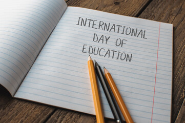 A notebook with pencils on it and the words International Day of Education