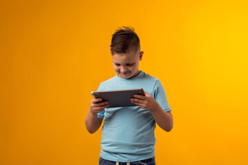 ?hild boy using tablet playing video game. Leisure and gadget addiction concept.