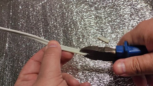 man cutting wires with nippers. electrician's work. nippers and wires. technology. work in production. wiring.