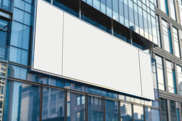 Obraz premium Large blank sign on a glass office building in an urban area.