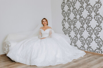 A woman in a white wedding dress is sitting on a couch