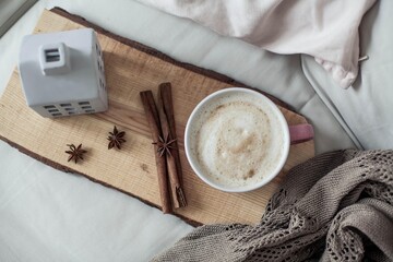 Home decor. Mug cappuccino, plaid, wooden tray, sofa. Cozy. Autumn.