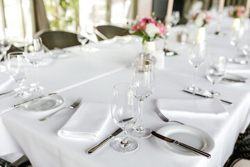 Festive table decorations, empty glasses and plates 