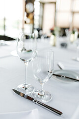 Festive table decorations, empty glasses and plates 