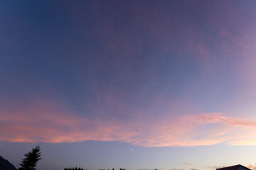 Obraz premium The sky, a canvas painted with strokes of ethereal pink, stretched across the horizon, casting a warm, rosy glow upon the tranquil landscape. As the sun dipped below the distant horizon.