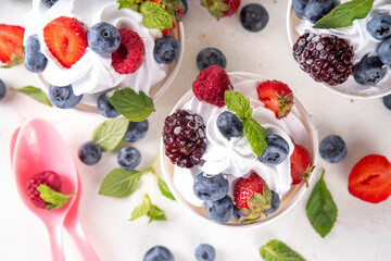 Frozen yogurt dessert with various berry toppings. Whipped creamy yoghurt ice cream with raspberry, strawberry, blueberry and mint