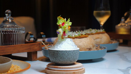 Gourmet dining setup featuring assortment of elegant dishes, beautifully plated on marble table, with glass of white wine in background. Fine Dining and Culinary Art.