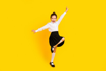 Full body photo of cute schoolgirl dancing chilling wear uniform isolated on yellow color background
