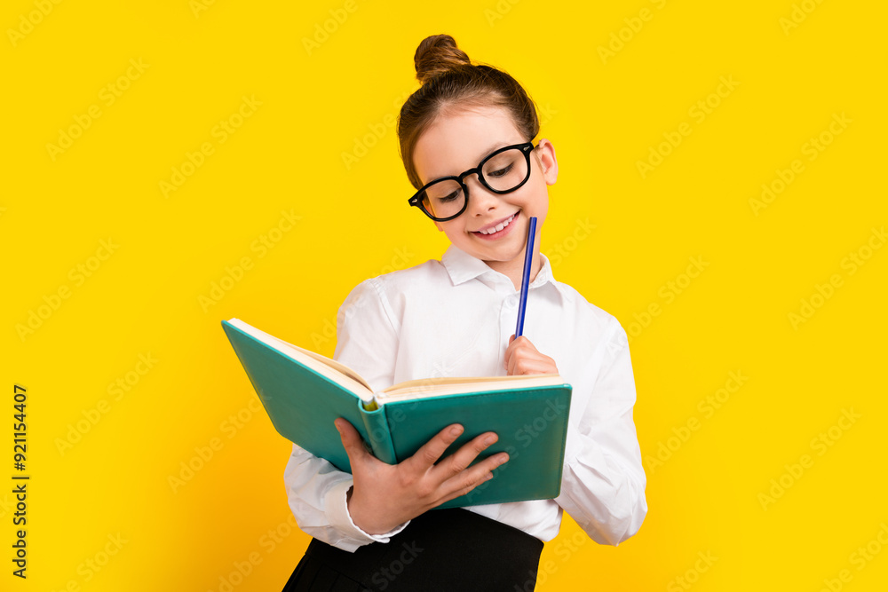 Sticker Photo of cute schoolgirl read book hold pencil wear uniform isolated on yellow color background