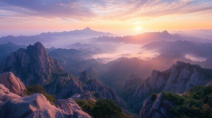 Fototapeta premium Sunrise over misty mountains with dramatic peaks and soft colorful sky