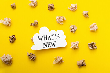 Fototapeta premium A yellow background with a white cloud and the word What's New written on it